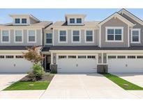 Attractive townhouse featuring a two-car garage, dormer windows, and green landscaping at 1237 Langham St, Avon, IN 46123