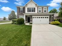 Inviting two-story home featuring a two-car garage and well-maintained front lawn at 18230 Sandy Cove Ln, Westfield, IN 46074
