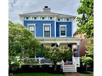 Charming two-story blue house with a welcoming front porch and beautifully landscaped yard at 2191 Greencroft St, Carmel, IN 46032