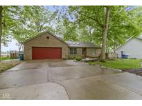 Charming brick ranch home with a red garage door and mature trees surrounding the property at 2397 Lincoln Dr, Cicero, IN 46034