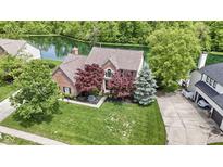 Beautiful brick home with mature trees and a well-manicured lawn overlooking a serene pond at 3708 Gould Dr, Carmel, IN 46033