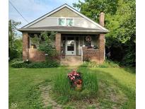 Charming brick home with front porch, lush landscaping, and inviting curb appeal at 3745 Winthrop Ave, Indianapolis, IN 46205