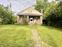Charming home features a brick exterior, inviting front porch and a brick pathway leading to the entrance at 3745 Winthrop Ave, Indianapolis, IN 46205