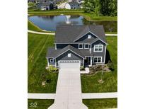 Beautiful home with gray siding, a large yard, and a pond with a fountain in the backyard at 3980 Railhead Ave, Westfield, IN 46074