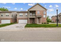 Charming two-story condo with brick and vinyl siding, attached garage, and small front balcony at 4261 Washington Blvd, Plainfield, IN 46168