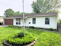 Charming single-story home featuring vinyl siding, a red garage door, and well-maintained front yard at 5416 Straw Hat Dr, Indianapolis, IN 46237