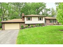 Charming ranch-style home with a two-car garage, brick accents, and mature trees and landscaping at 6126 Rucker Rd, Indianapolis, IN 46220