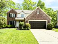 Charming two-story brick home with attached garage and a well-manicured front yard at 6242 Carrington Dr, Indianapolis, IN 46236