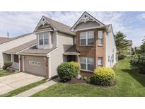 Two-story home featuring brick and vinyl siding, with an attached garage and manicured front lawn at 6542 E Edna Mills Dr, Camby, IN 46113