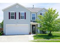 Charming two-story home featuring a well-manicured lawn and attached two car garage at 7737 Wolfgang Pl, Indianapolis, IN 46239