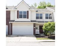 Charming two-story townhome featuring a spacious garage and a welcoming front entrance with beautiful landscaping at 8317 Pine Branch Ln, Indianapolis, IN 46234