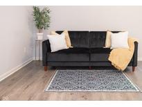 Living room featuring a black couch, accent pillows, and area rug at 8317 Pine Branch Ln, Indianapolis, IN 46234