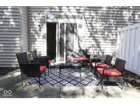 View of the rear patio with outdoor seating, a decorative rug, and a sliding glass door entrance at 8317 Pine Branch Ln, Indianapolis, IN 46234
