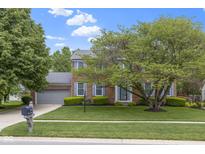 Charming two-story brick home with a well-manicured lawn and mature landscaping in a suburban neighborhood at 8430 Harrison Pkwy, Fishers, IN 46038