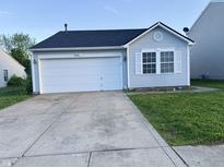 Charming single-story home featuring a one-car garage, light blue siding and a well-maintained lawn at 9145 Blue Pine Dr, Indianapolis, IN 46231