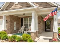 Inviting front porch with rocking chairs, 'Welcome' sign, and American flag at 9166 Lieven St, Avon, IN 46123