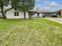 Charming single-story home with a lush green lawn, covered entry, and attached carport at 9490 E 36Th Pl, Indianapolis, IN 46235