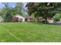 Charming single-story home with a brick facade, well-manicured lawn, and mature trees at 9885 Oakleaf Way, McCordsville, IN 46055