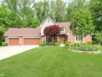 Beautiful brick home featuring an attached three car garage and mature landscaping at 10350 Courageous Dr, Indianapolis, IN 46236