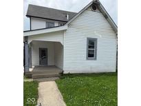 Charming home featuring white siding, a welcoming front porch, and a well-maintained lawn at 1322 S Belmont Ave, Indianapolis, IN 46221