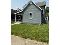 Charming home featuring light gray siding, a well-manicured lawn, and a bright white window frame at 1322 S Belmont Ave, Indianapolis, IN 46221