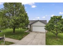 Charming single-story home with a two-car garage and a well-maintained lawn and landscaping at 1431 Evergreen Dr, Greenfield, IN 46140