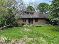 Charming brick home with a landscaped front yard, mature trees, and a cozy, inviting appearance at 310 S Shady Ln, Muncie, IN 47304