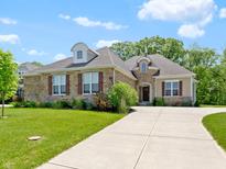 Charming stone and siding home with a well-manicured lawn and long driveway at 4125 Sugar Pine Ln, Zionsville, IN 46077