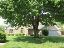 Charming brick home with a well-manicured lawn and a large tree providing shade at 4288 Silver Hill Dr, Greenwood, IN 46142