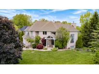 Stunning brick home with mature landscaping, lush green lawn, and classic architectural details at 434 Sheffield Ct, Carmel, IN 46032