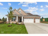 Beautiful brick home with a three-car garage, a well-kept lawn, and a cozy front porch under a blue sky at 5032 Carmine St, Brownsburg, IN 46112