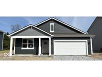 Charming single-story home featuring a white garage door, dark siding, and eye-catching architectural details at 5203 Cartland Dr, Indianapolis, IN 46239