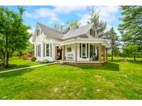 Charming two-story farmhouse with a covered porch and well-maintained lawn at 5335 W 550 S, Trafalgar, IN 46181