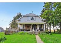 Charming two-story home featuring a covered front porch, steps to the front door, and mature trees on a lush green lawn at 5758 N 1200 E, Sheridan, IN 46069