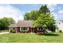 Charming brick home with a well-manicured lawn and mature trees at 6040 Manker St, Indianapolis, IN 46227