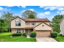 Charming two-story home with a well-manicured lawn and attached two car garage at 6609 Fountain Springs Blvd, Indianapolis, IN 46236