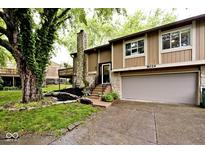 Charming home featuring stone accents, landscaping, and an attached two-car garage at 8024 Sunfield Ct # 5-B, Indianapolis, IN 46214