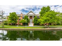 Stunning exterior view of a brick condo building with water feature and lush green landscaping at 8690 Jaffa Ct W Dr # 28, Indianapolis, IN 46260