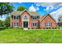 Charming two-story brick home with manicured lawn, black shutters, and classic architectural details at 9158 Oak Knoll Ln, Fishers, IN 46037