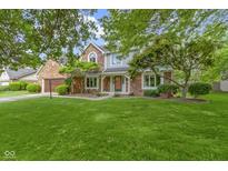 Charming two-story brick home with a well-maintained lawn and mature landscaping at 974 Arrowwood Dr, Carmel, IN 46033