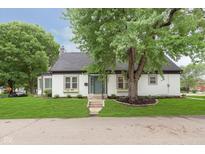 Charming home with lush lawn and mature trees, creating a serene and inviting outdoor space at 1502 Burdsal Pkwy, Indianapolis, IN 46208