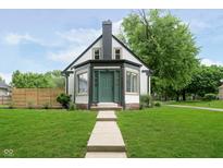 Charming home with a manicured lawn and a walkway leading to the front door at 1502 Burdsal Pkwy, Indianapolis, IN 46208