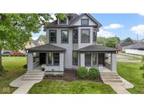 Charming two-story duplex featuring well-maintained landscaping and a classic facade with inviting front porches at 1526 Carrollton Ave, Indianapolis, IN 46202