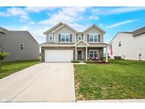 Charming two-story home with a manicured lawn, attached two-car garage, and inviting front porch at 1893 Glenmoor Ct, Columbus, IN 47201