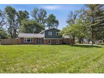 Charming brick and siding two-story home with a spacious front yard and mature trees at 2009 Friendship Dr, Indianapolis, IN 46217