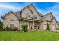 Charming two-story brick home featuring a well-manicured lawn, tasteful landscaping, and a welcoming front porch at 3247 Moonlight Ct, Columbus, IN 47203