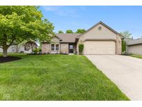 Charming single-story home with a well-manicured lawn and attached two-car garage at 3630 Foxtail Dr, Indianapolis, IN 46235