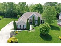 Stunning aerial view of brick home with pristine landscaping and mature trees providing shade and privacy at 3815 Harrison Crossing Ln, Greenwood, IN 46142