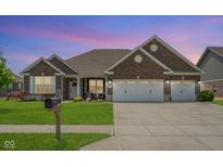 Charming brick home featuring a three-car garage, well-manicured lawn, and inviting curb appeal at 4659 W Otway Ln, New Palestine, IN 46163