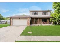 Charming two-story home featuring a brick facade, a two-car garage, and a well-manicured front lawn at 5236 Honey Comb Ln, Indianapolis, IN 46221